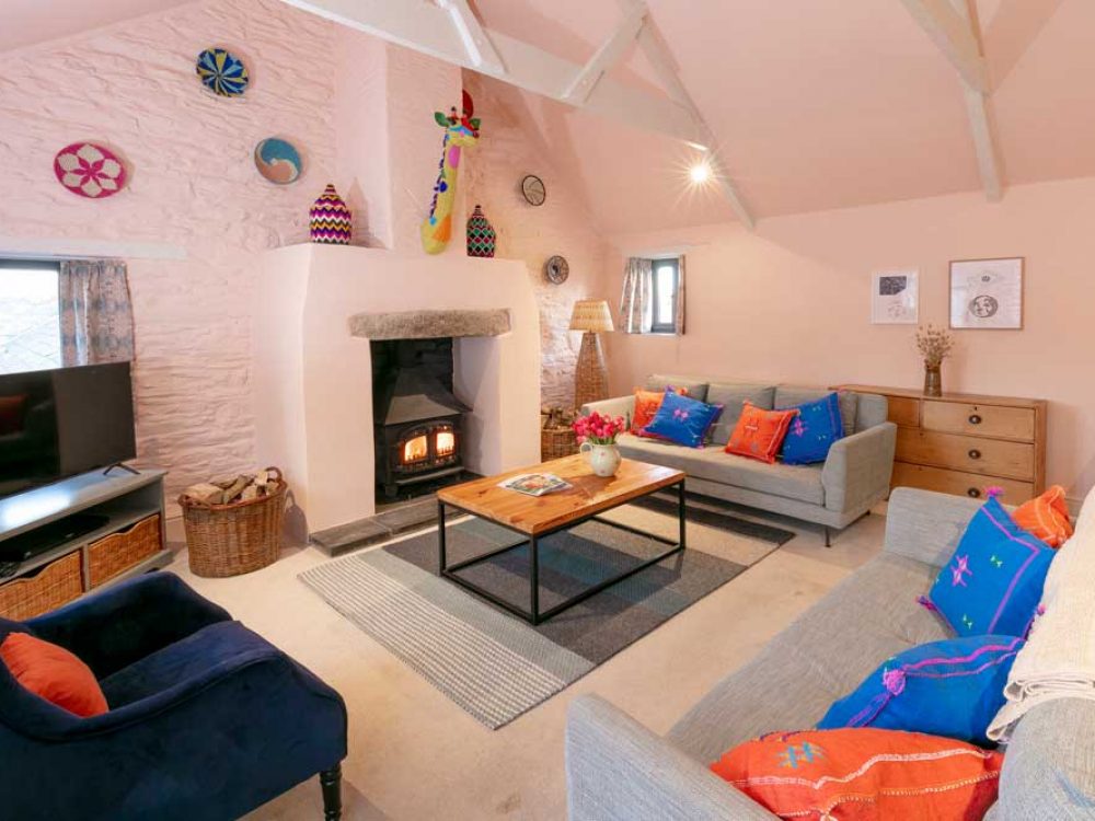 Interior shot of the living space in Granary Cottage with a colourful giraffe above the fireplace.