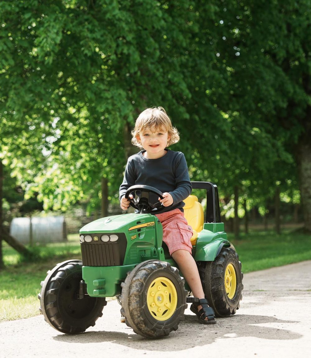 An young boy sitting on a mini tractor at Tredethick