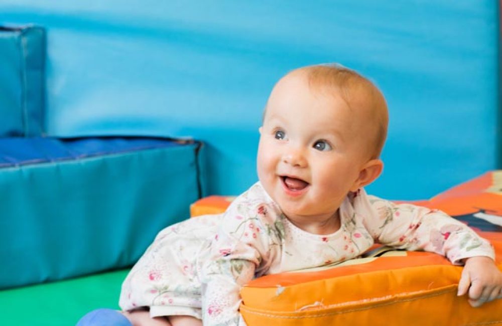 Happy baby playing with a soft play sponge toy
