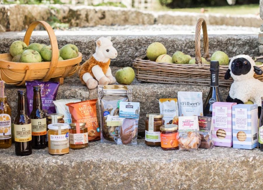 Local foods, drinks and animal toys on stones steps with hampers of apples