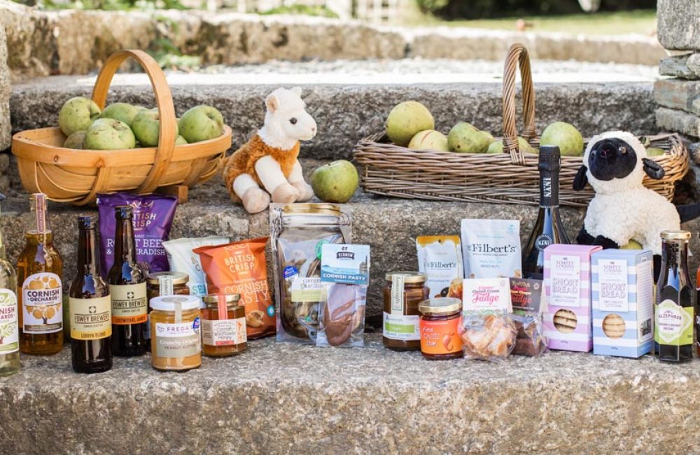Local foods, drinks and animal toys on stones steps with hampers of apples