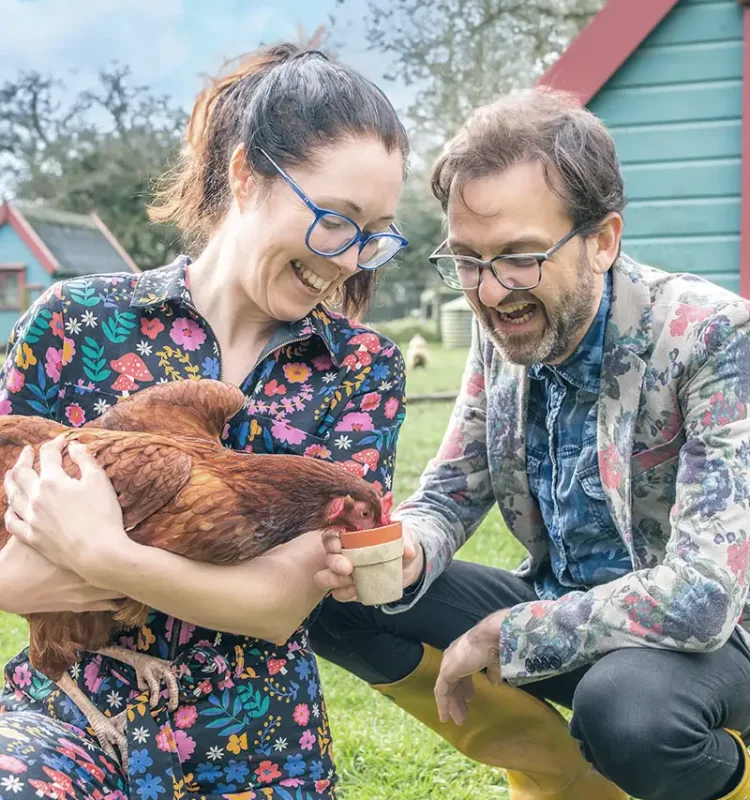 Zoe and Yello holding and feeding a chicken at Tredethick Farm Cottages.