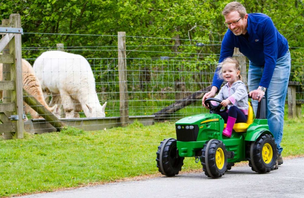 Girl enjoying a ride on a miniature John Deare