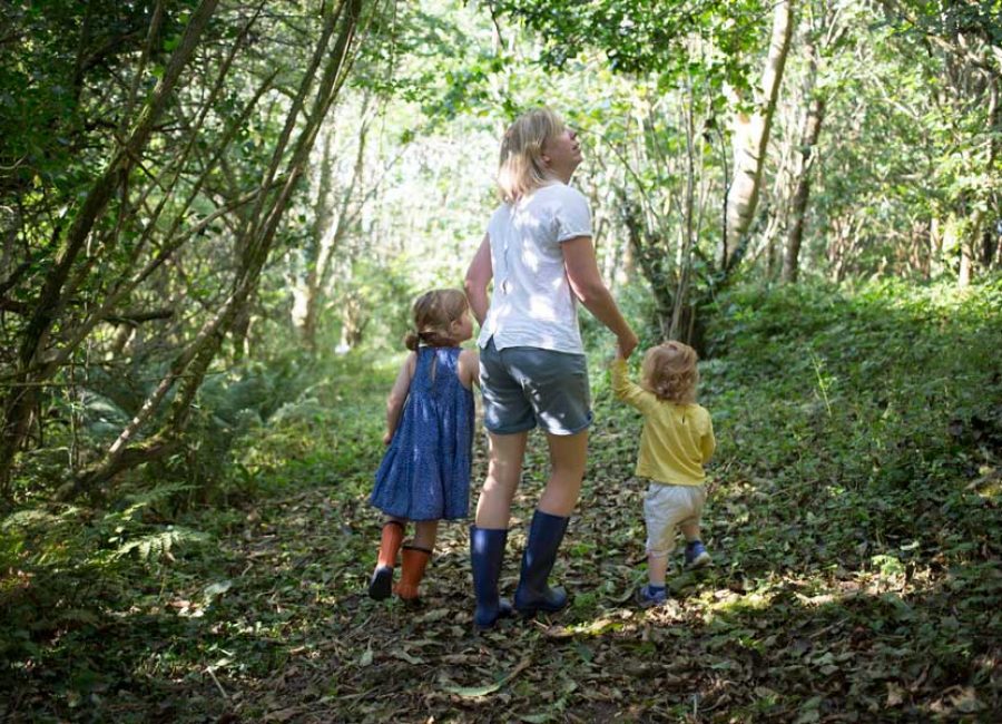 A young family exploring the woodland around Tredethick